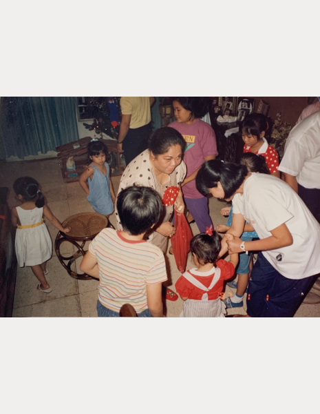 Beatrice Livioco with her Mother and family playing a traditional Filipino coin game