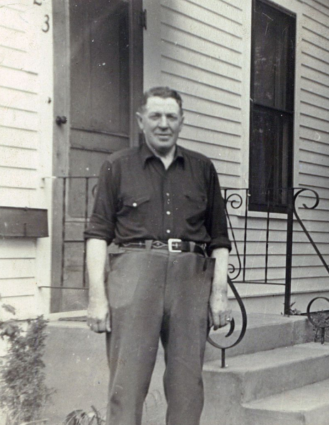 Black and white image of Tim O'Leary's Grandfather Barry O'Leary in front of a house