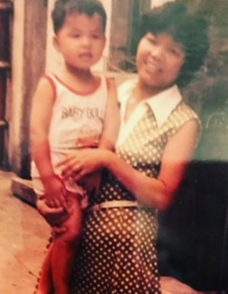 Todd Yu as a child being held on his Mother's hip